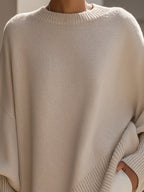 Oversized poncho sweater knit close-up with ribbed crew neckline, light beige