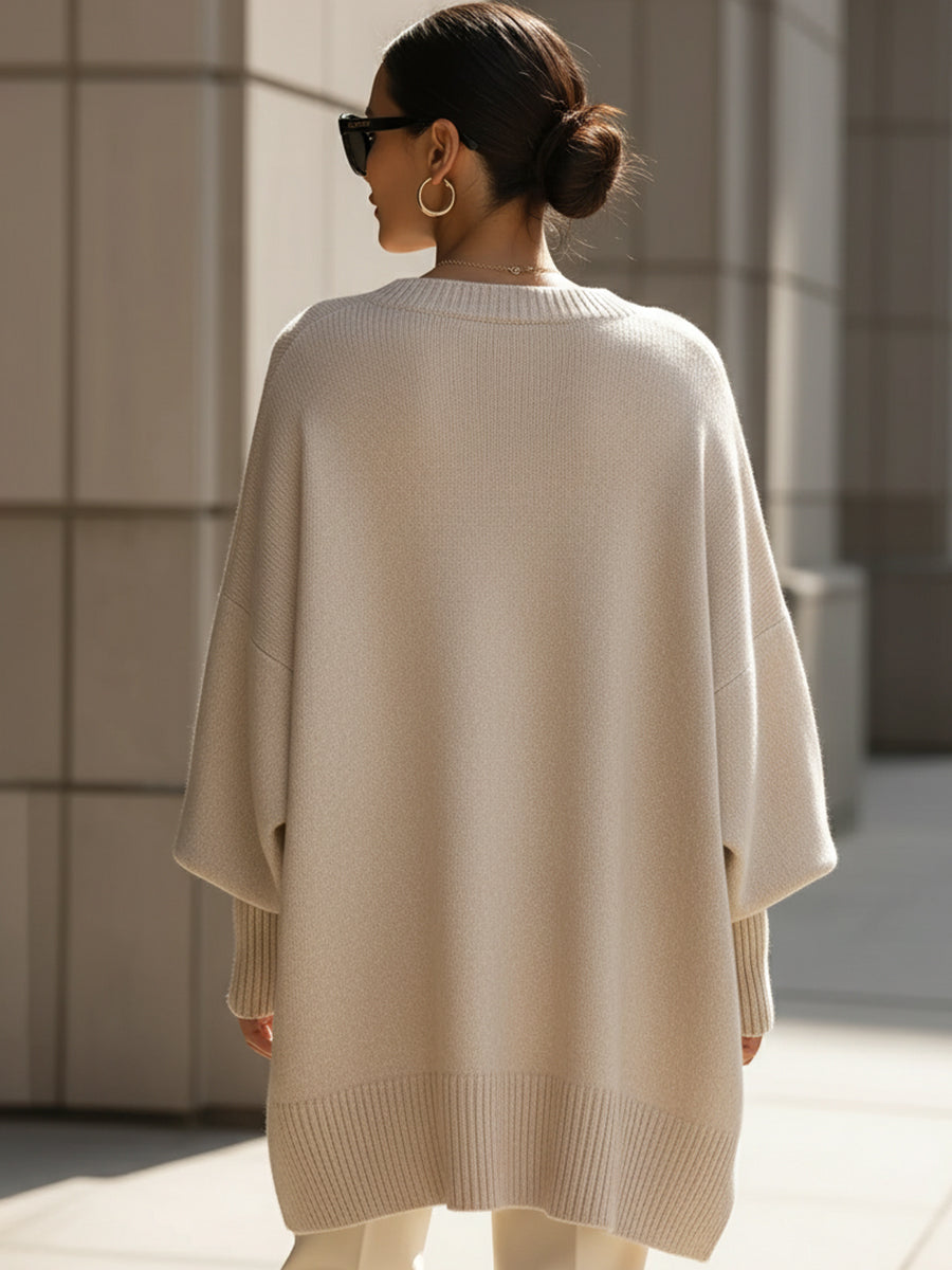 Oversized poncho sweater, back view with ribbed hem, light beige
