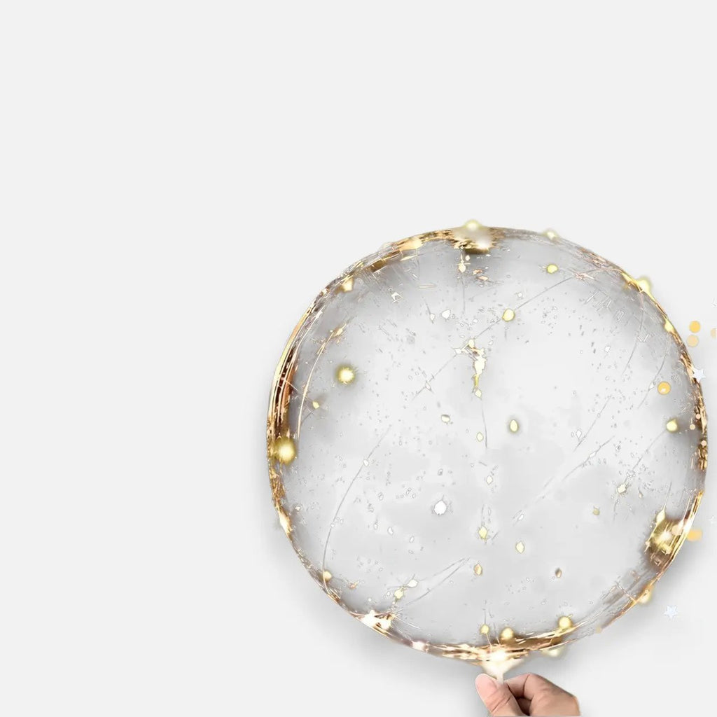 Transparent LED balloon with warm white micro lights, held in a hand