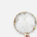 Transparent LED balloon with warm white micro lights, held in a hand