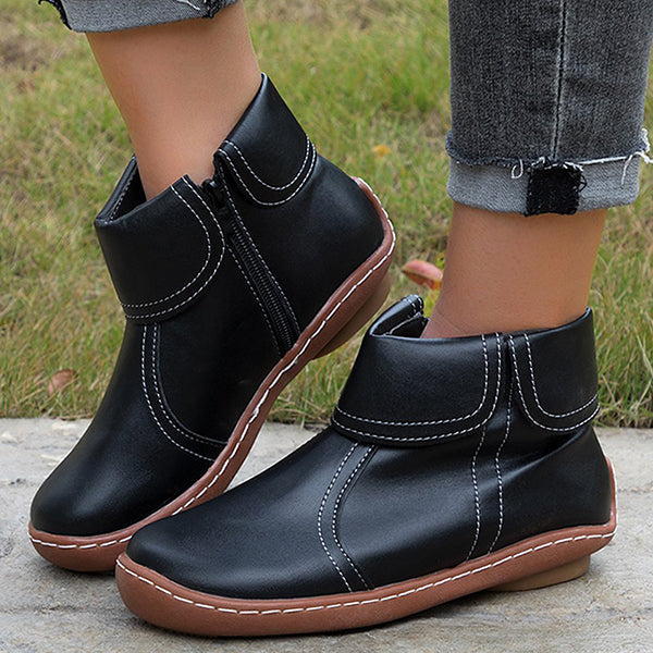 Women’s vintage-style ankle boots, black with contrast white stitching and side zipper.