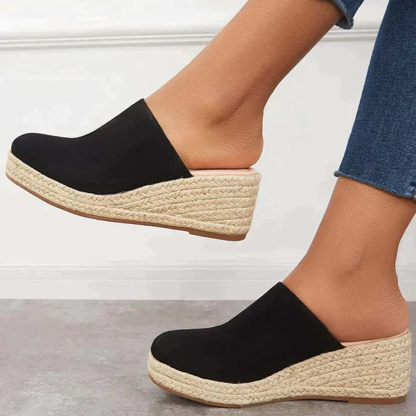 Black closed-toe espadrille wedge mule with slip-on design and braided jute platform.