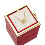 Red jewelry gift box with gold heart pendant necklace on white display pillow