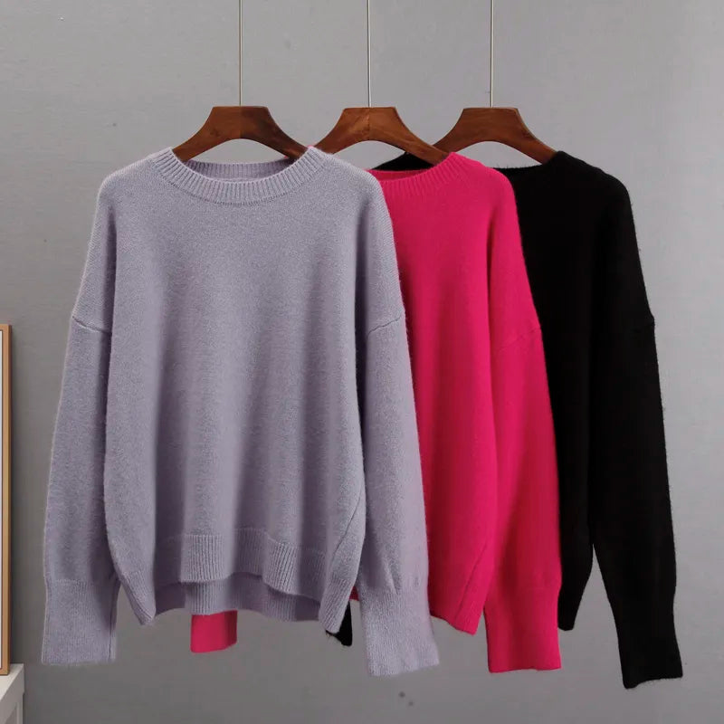 Crewneck cashmere sweaters on hangers: light gray, fuchsia, and black.