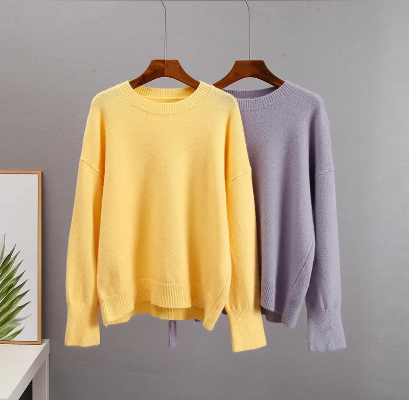 Cashmere crewneck sweaters on hangers: yellow and light lavender.