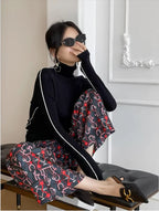 Black turtleneck sweater with white contrast trim along the sleeves and shoulders