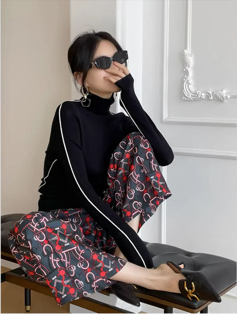 Black turtleneck sweater with white contrast trim along the sleeves and shoulders
