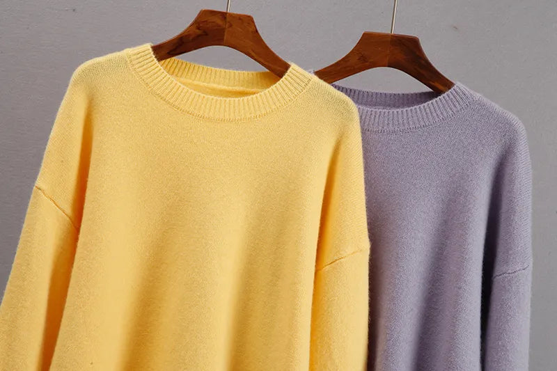 Yellow cashmere crewneck sweater with long sleeves; lavender sweater beside it.