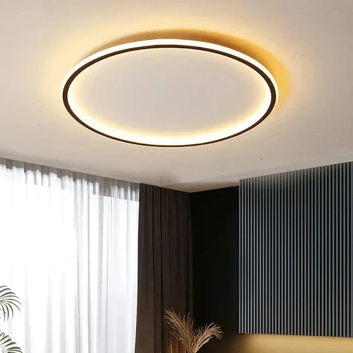 Round LED flush mount ceiling light with dark outer ring and warm glowing halo