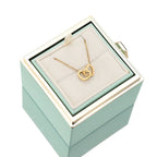Teal jewelry gift box with gold heart pendant necklace on white display pillow