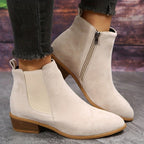 Off-white suede ankle boots with elastic side panels and low stacked heel