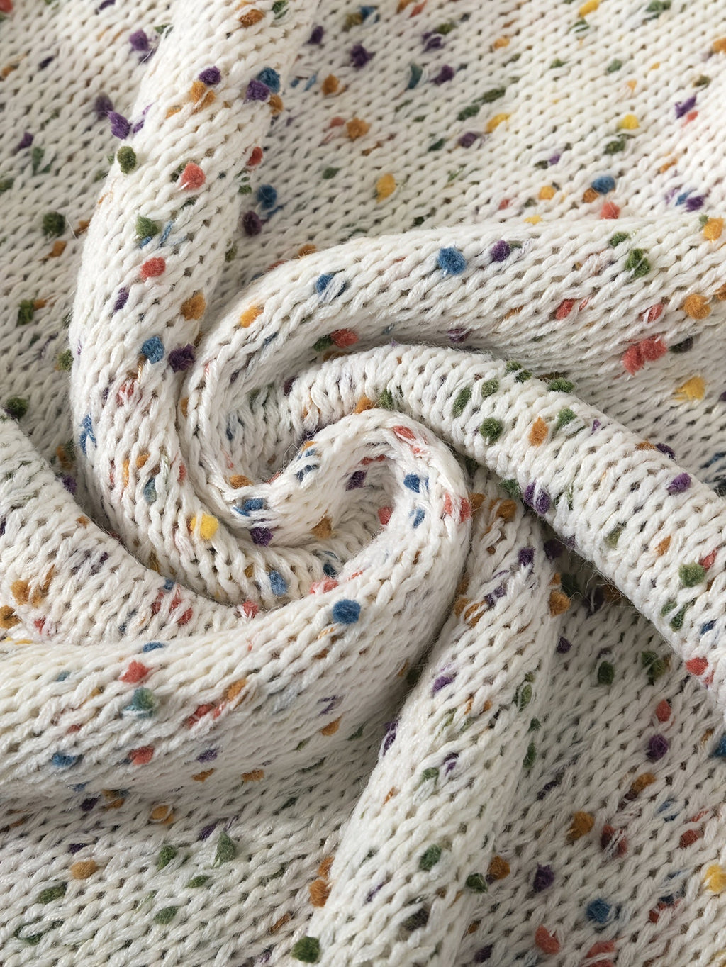 Confetti knit sweater fabric close-up in off-white with multicolor speckled flecks