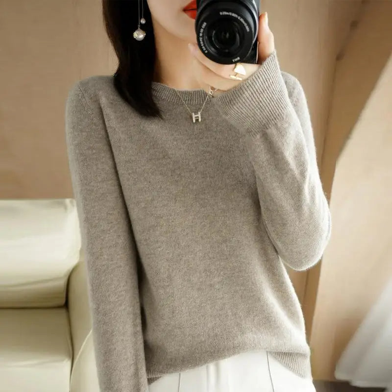 Light gray crewneck pullover sweater with long sleeves and ribbed cuffs and hem