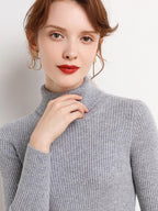 Gray ribbed turtleneck sweater worn by a model with long sleeves