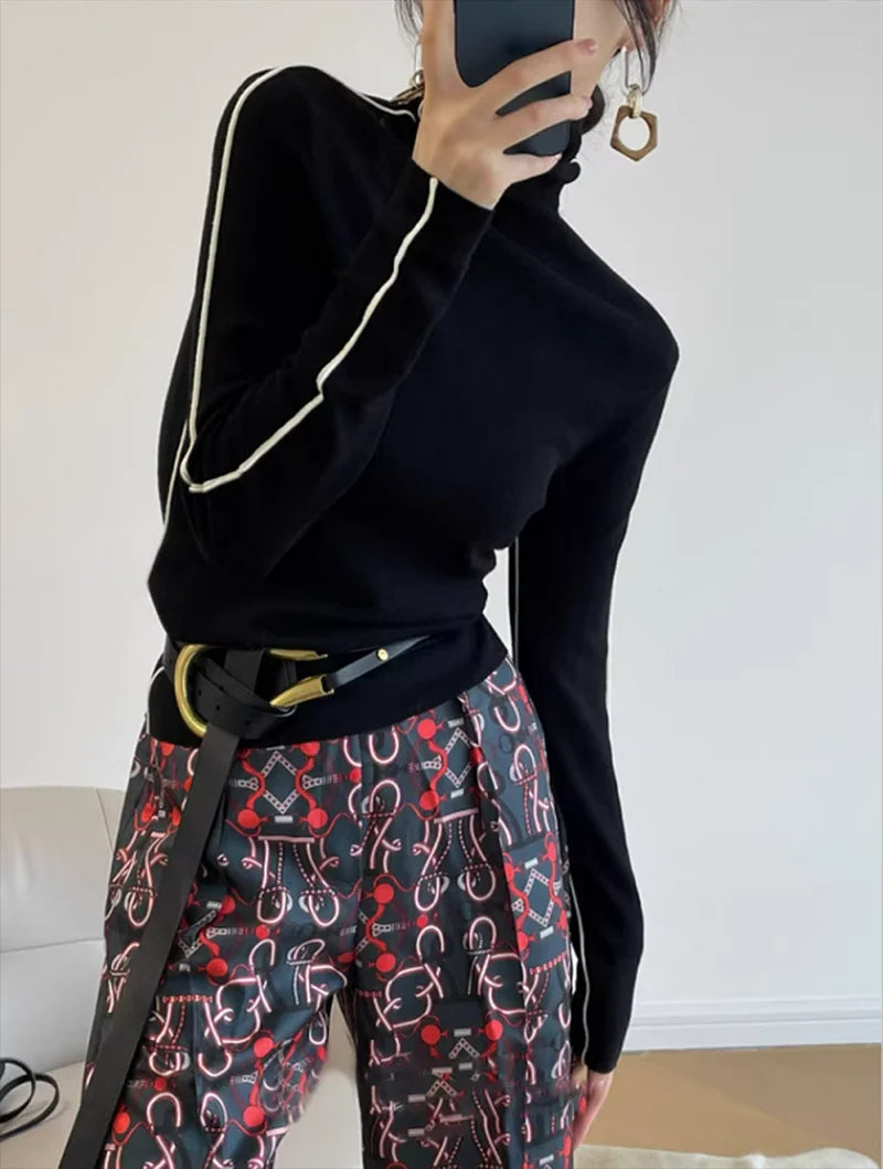 Black ribbed turtleneck top with white contrast trim at the collar and sleeves