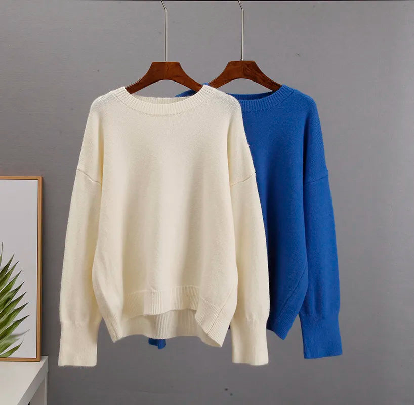 Cream cashmere crewneck sweater and blue crewneck sweater on hangers.