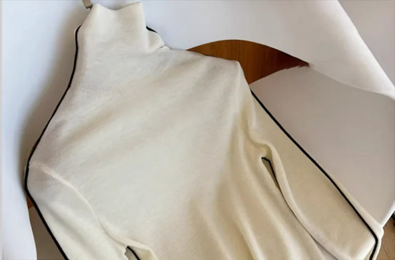 Cream knit turtleneck sweater with a high neckline and long sleeves