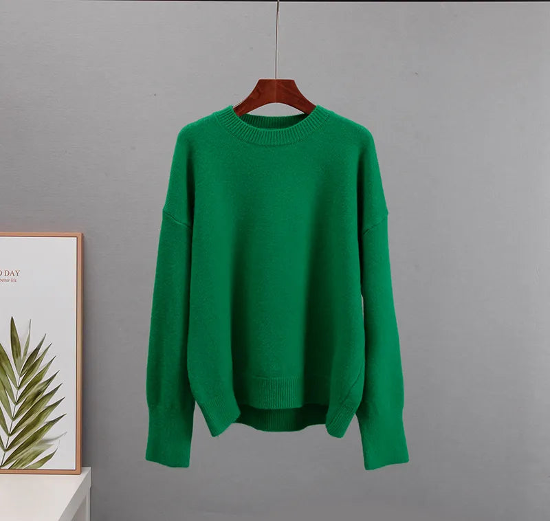 Green cashmere crewneck sweater on hanger with long sleeves and ribbed hem.
