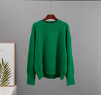 Green cashmere crewneck sweater on hanger with long sleeves and ribbed hem.