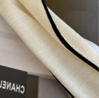 Cream turtleneck sleeve with black contrast trim along the inner edge