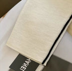 Cream turtleneck fabric with black trim along the side seam