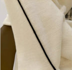 Cream knit turtleneck with black contrast piping along the neckline seam