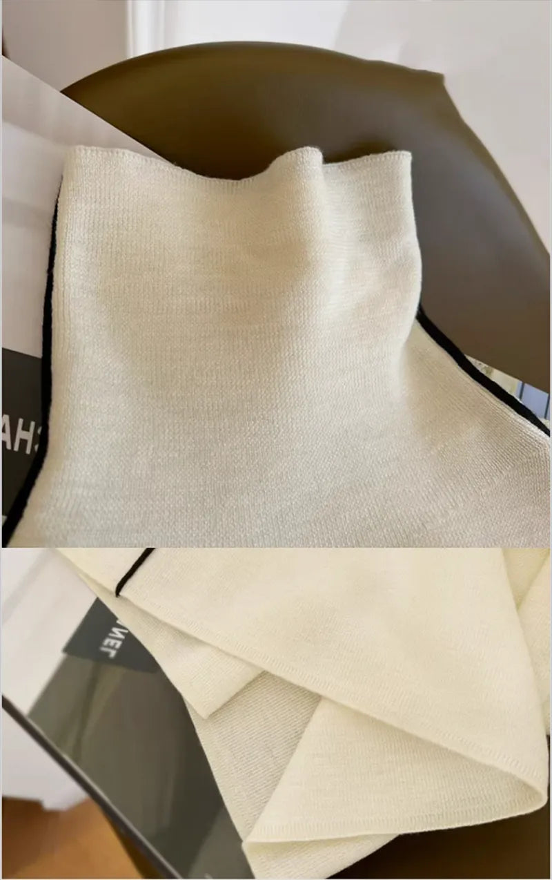 Cream turtleneck sweater with ribbed collar and black-trim piping