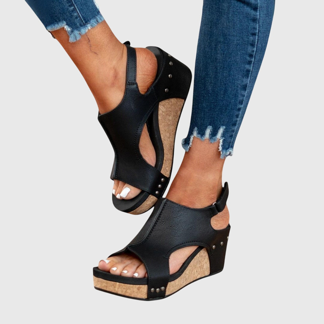 Black open-toe wedge sandals with two straps and adjustable ankle buckle with studs.