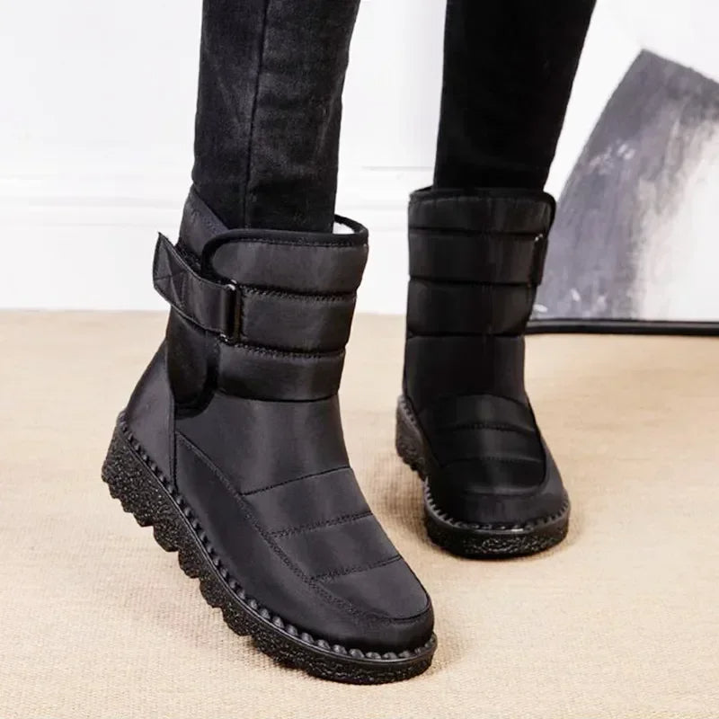 Women's black quilted mid-calf boots with side strap, seam lines, and grippy sole