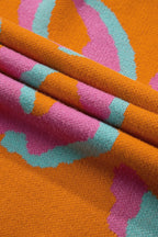 Close-up of orange, pink, and teal leopard-style knitted fabric texture.
