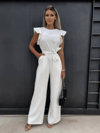 White wide-leg jumpsuit with flutter sleeves and waist-tie belt