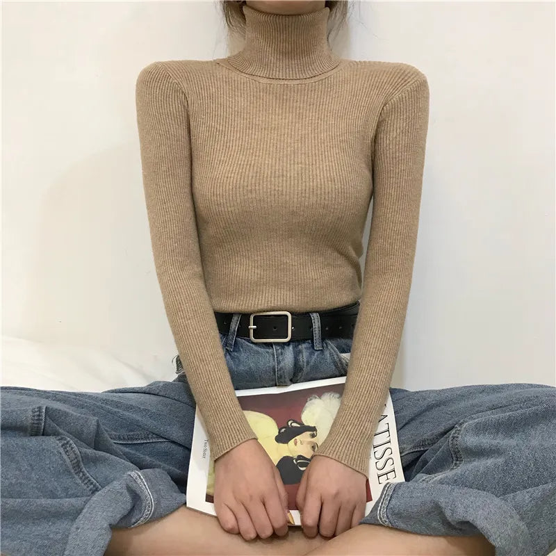 Tan ribbed turtleneck sweater with long sleeves and a fitted high collar.