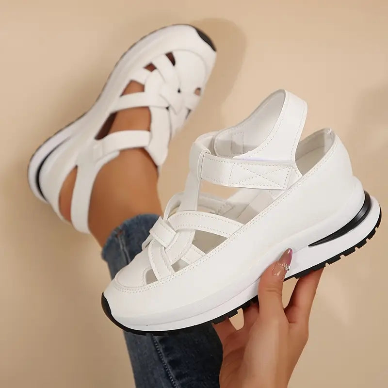 White platform sandals with crisscross straps and thick sole, angled close-up