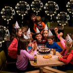 Glowing warm white LED transparent balloons with light strings at a birthday table