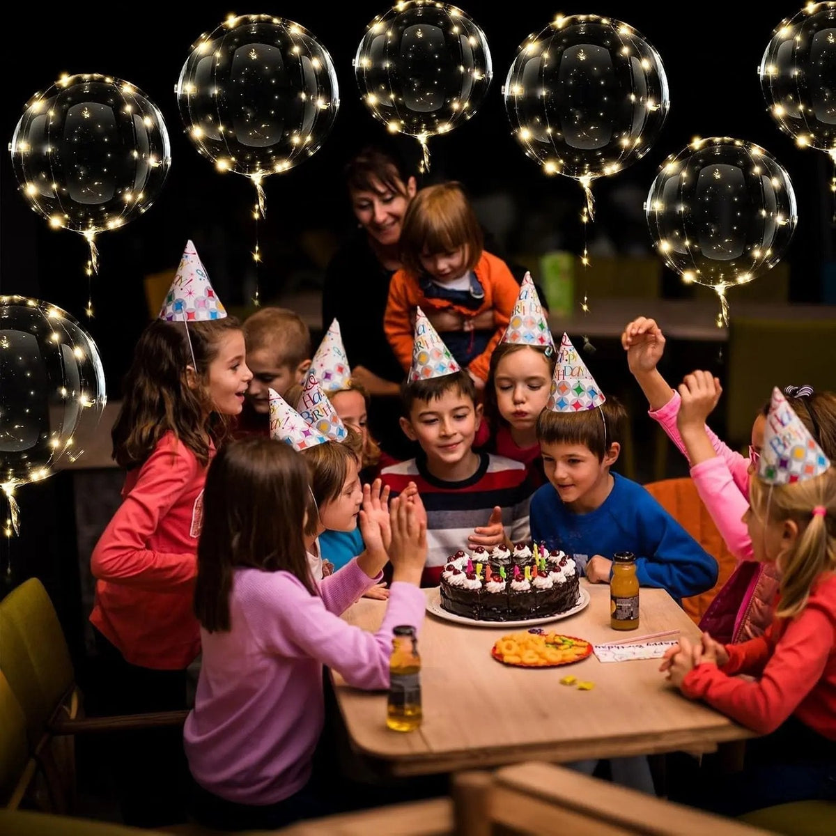 Glowing warm white LED transparent balloons with light strings at a birthday table