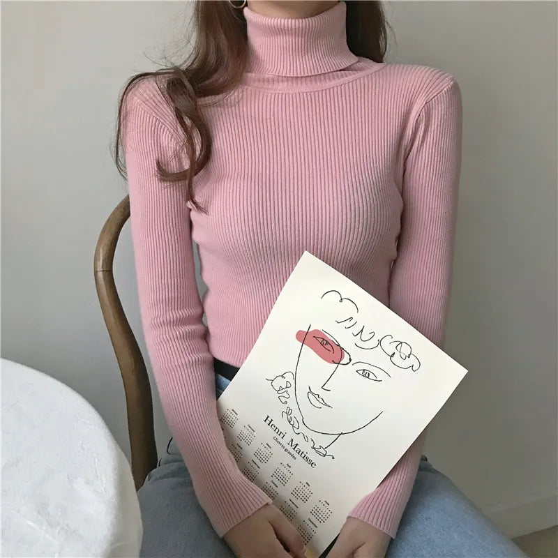 Soft pink ribbed turtleneck sweater with long sleeves and a close high collar.