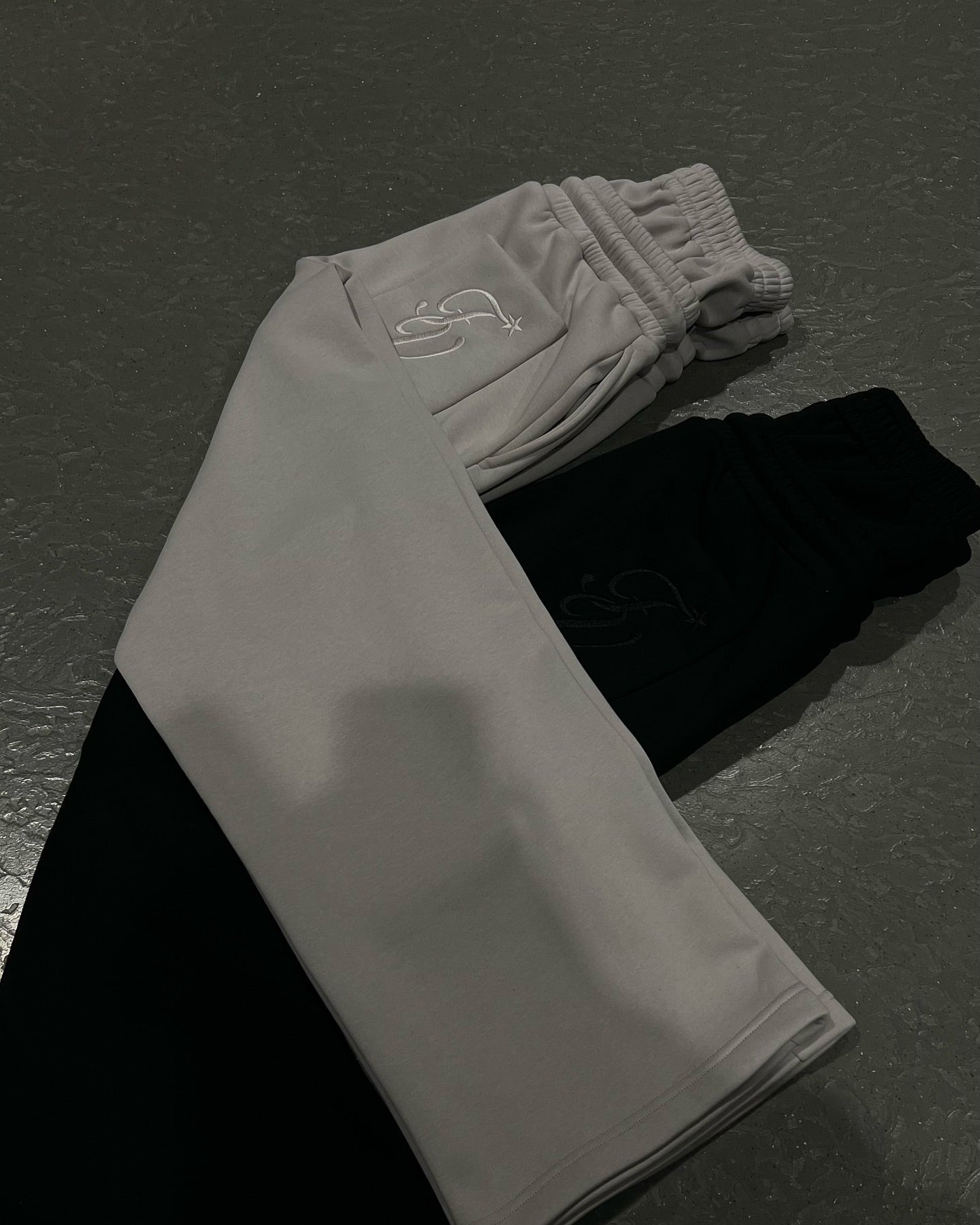 Unisex joggers set showing light gray and black pants with drawstring waists