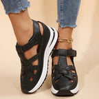 Black platform sandals with ankle strap and cross upper, rear view