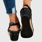 Black cushioned wedge sandals with perforated side straps and a padded heel platform.
