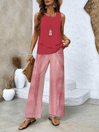 Red sleeveless blouse with layered hem and wide-leg trousers with red-and-white stripes