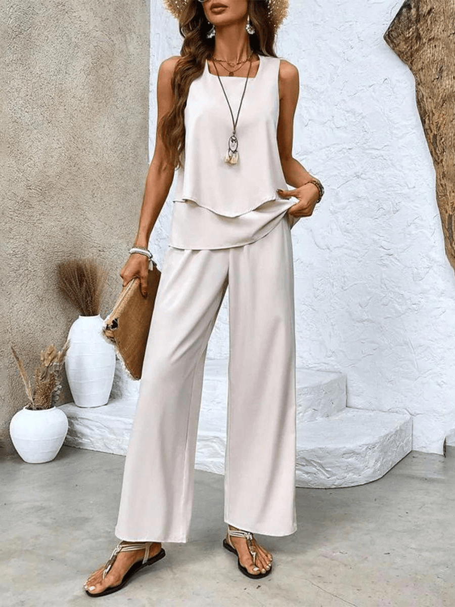 White sleeveless layered blouse with wide-leg trousers in solid white