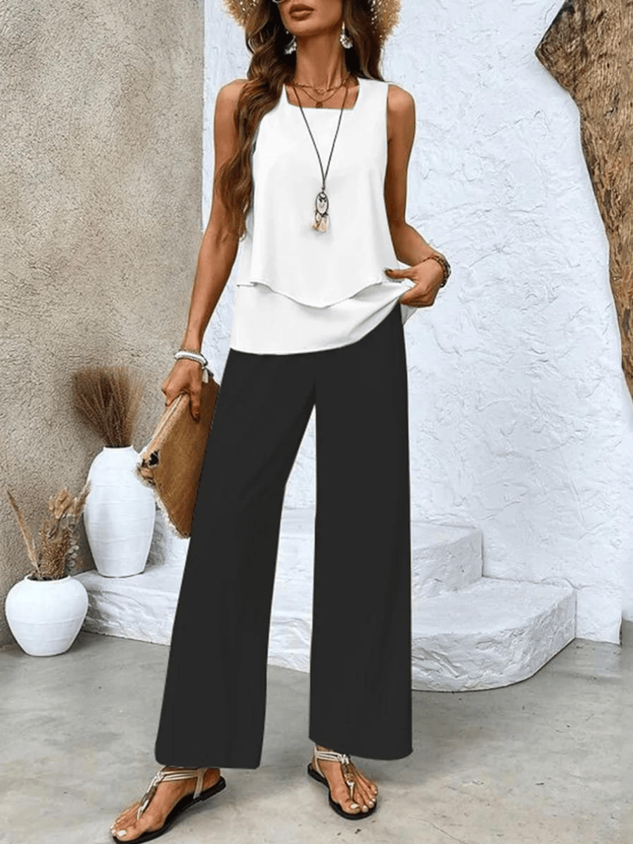 White sleeveless layered blouse with wide-leg trousers in solid black