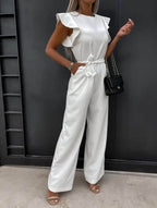 White wide-leg jumpsuit with flutter sleeves and waist-tie belt, side view