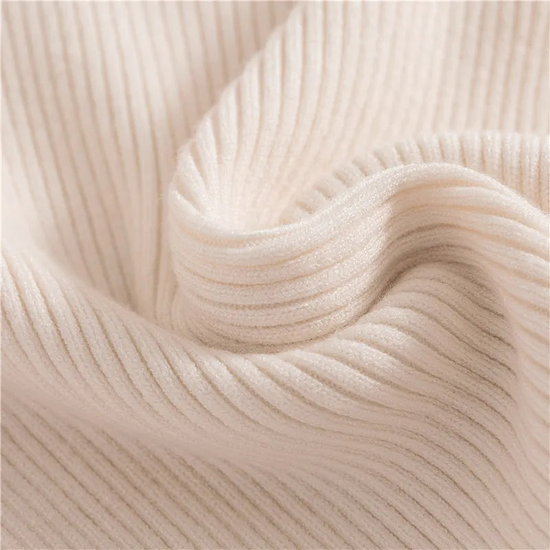 Cream ribbed turtleneck sweater with snug folded collar and soft knit texture