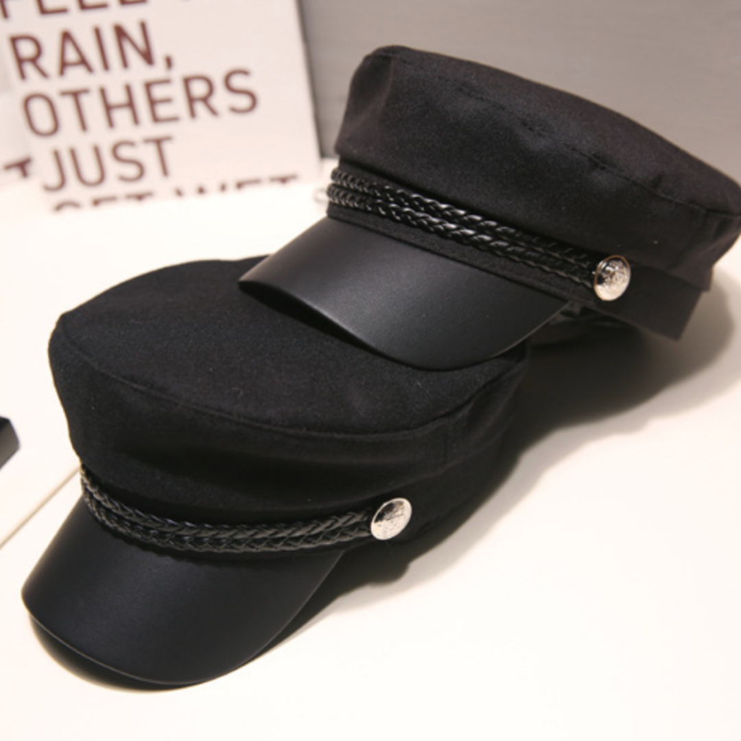 Two black peaked caps with braided cord trim and round metal buttons, stacked