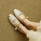 White Mary Jane flat shoes with twisted strap and pearl button detail, low block heel