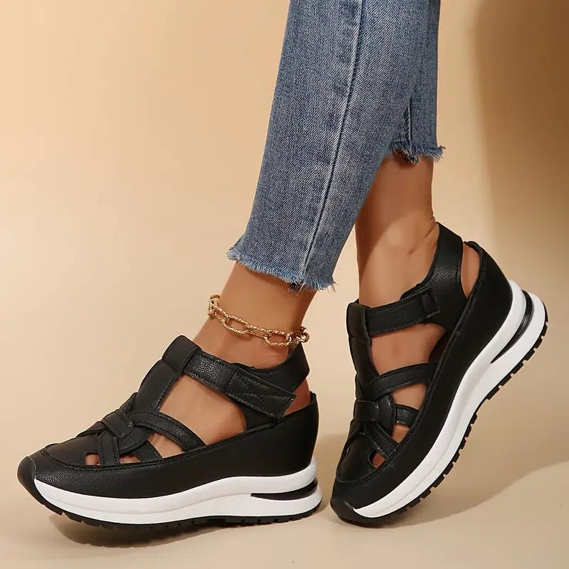 Black platform sandals with cross straps and chunky sole, side angle