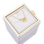 White jewelry gift box with gold heart pendant necklace on white display pillow