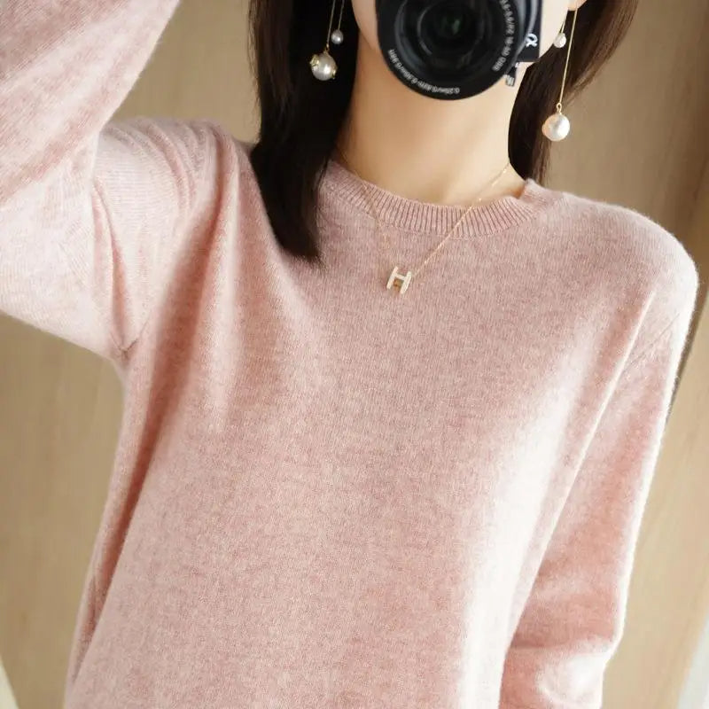 Pink crewneck pullover sweater with long sleeves and ribbed cuffs and hem