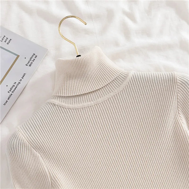 Ribbed turtleneck sweater in off-white/cream, close-up of layered mock neck